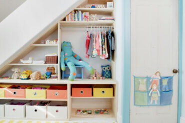 The space behind the staircase is transformed into shelves for storing clothes and toys and other box organizers.